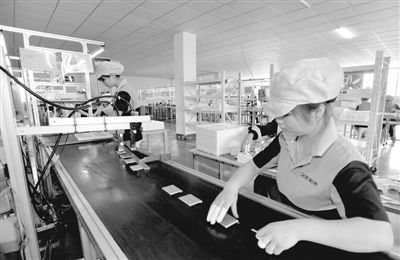 工人正在生產(chǎn)手機(jī)電池 工人正在生產(chǎn)手機(jī)電池