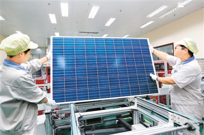 江蘇連云港神舟新能源有限公司工人在太陽能光伏生產(chǎn)線上忙碌。